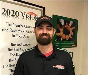 Male SERVPRO technician with a beard smiling at the camera.