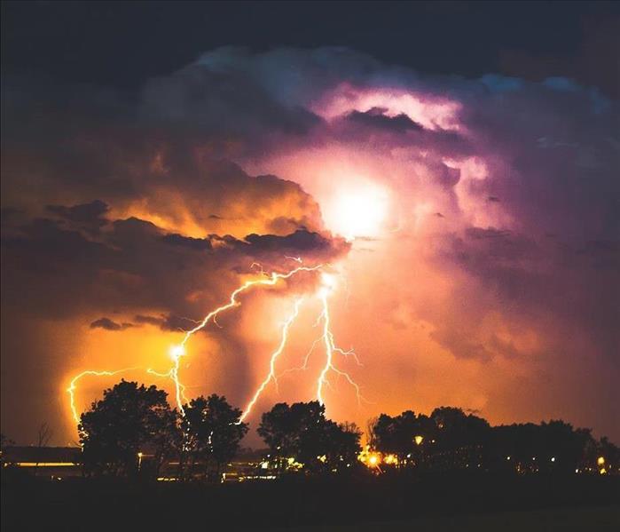 Lightning strike at night on purple sky.
